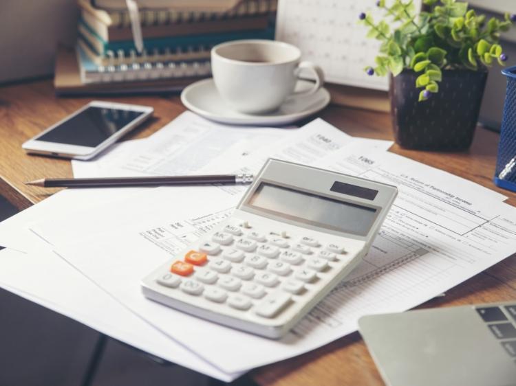 kalkulator na biurku z rachunkami i kawą